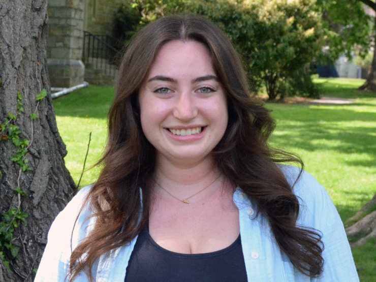 College student Teigan Brown smiles while standing outdoors on the campus of Muhlenberg College.